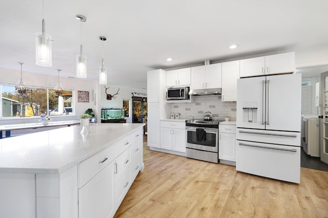 3055 Ryan Ln, Redding, CA 96003 - kitchen with appliances with stainless steel finishes, under cabinet range hood, backsplash, white cabinetry, and light wood-type flooring