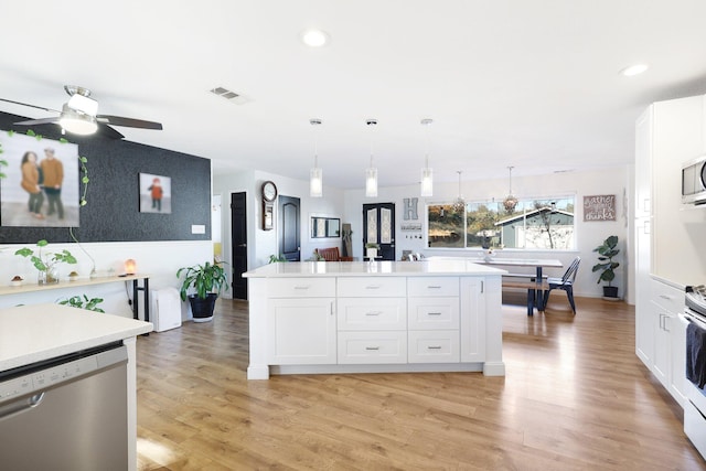 3055 Ryan Ln, Redding, CA 96003 - kitchen featuring stainless steel appliances, light countertops, white cabinets, a kitchen island, and ceiling fan