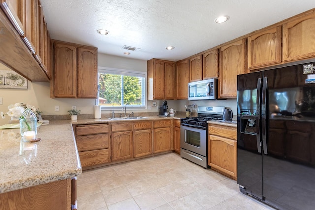 676 Country Oak Dr, Redding, CA 96003 - kitchen with appliances with stainless steel finishes, brown cabinets, recessed lighting, a textured ceiling, and light tile patterned floors