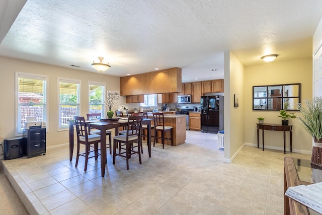 676 Country Oak Dr, Redding, CA 96003 - dining room with light tile patterned floors, a textured ceiling, and recessed lighting