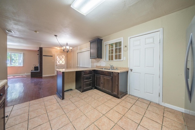 1440 Oakdale Ln, Redding, CA 96002 - kitchen featuring light countertops, a chandelier, a peninsula, open floor plan, and refrigerator
