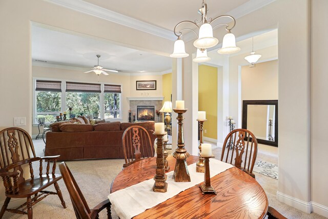 1835 Dellwood Dr, Redding, CA 96003 - dining room with crown molding, ceiling fan, a warm lit fireplace, a chandelier, and light carpet