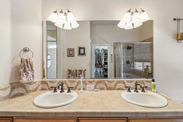 1835 Dellwood Dr, Redding, CA 96003 - bathroom featuring a chandelier, double vanity, a shower stall, and a spacious closet