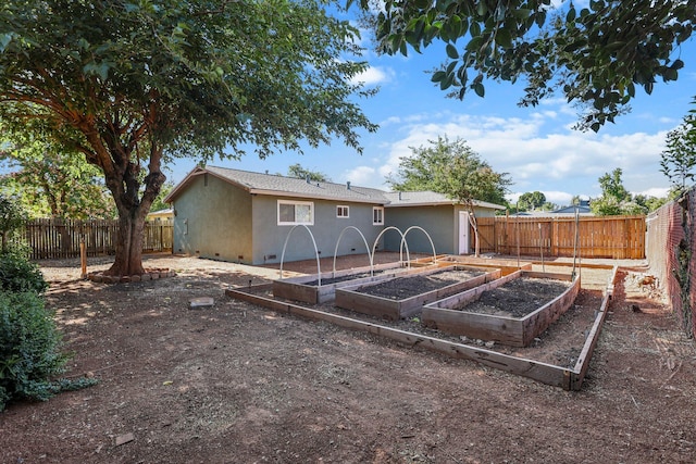 2092 Phobos Ct, Redding, CA 96002 - rear view of property featuring crawl space, a garden, stucco siding, and a fenced backyard