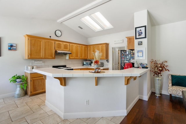 2834 Aspen Glow Ln, Redding, CA 96001 - kitchen with a peninsula, tile countertops, range, and a kitchen bar
