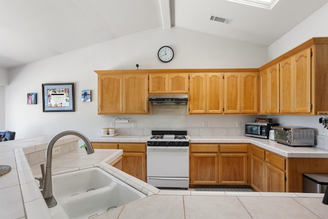 2834 Aspen Glow Ln, Redding, CA 96001 - kitchen featuring white gas range oven, under cabinet range hood, tile countertops, and stainless steel microwave