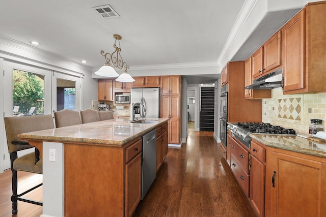 3428 Adams Ln, Redding, CA 96002 - kitchen with stainless steel appliances, under cabinet range hood, a kitchen bar, brown cabinets, and dark wood-style flooring