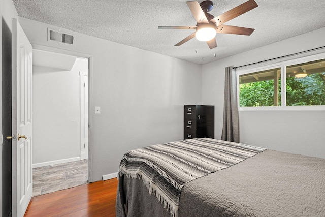 3428 Adams Ln, Redding, CA 96002 - bedroom with wood finished floors, a textured ceiling, and a ceiling fan