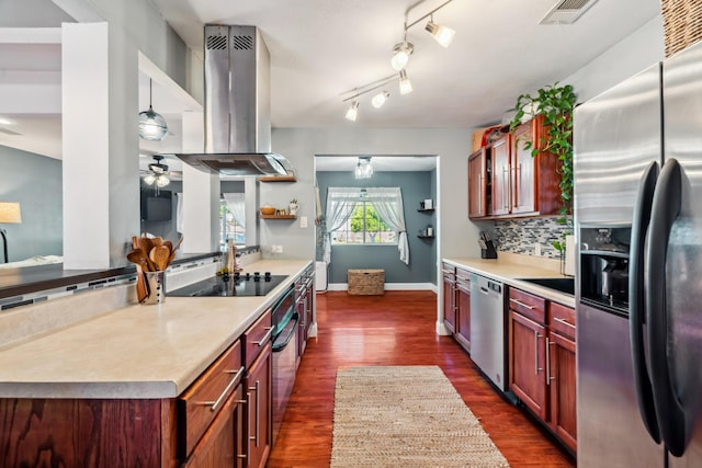 2623 Freebridge St, Redding, CA 96001 - kitchen with appliances with stainless steel finishes, island exhaust hood, decorative backsplash, a ceiling fan, and dark wood-type flooring