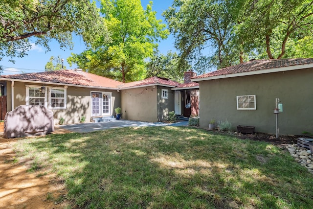 2623 Freebridge St, Redding, CA 96001 - back of house with stucco siding, a patio, a yard, and a chimney