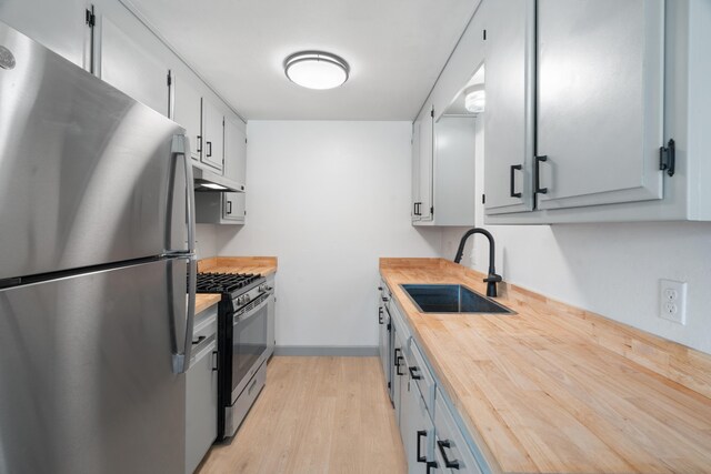 3704 Polaris Way, Redding, CA 96002 - kitchen with freestanding refrigerator, gas range oven, butcher block counters, under cabinet range hood, and light wood-style flooring