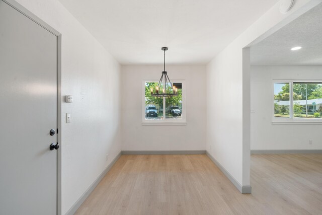 3704 Polaris Way, Redding, CA 96002 - unfurnished dining area with light wood-style flooring and a chandelier