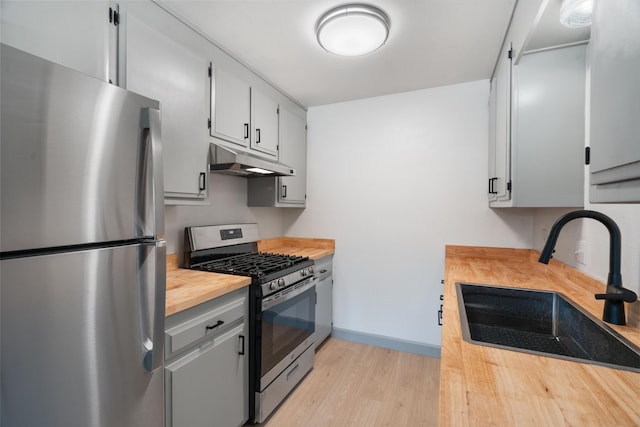 3704 Polaris Way, Redding, CA 96002 - kitchen featuring appliances with stainless steel finishes, under cabinet range hood, wooden counters, and light wood-style floors