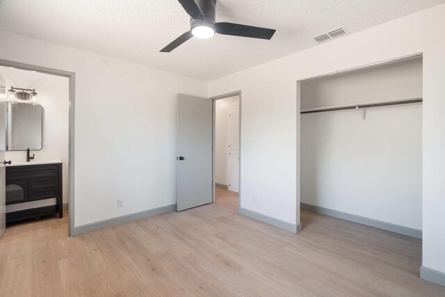 3704 Polaris Way, Redding, CA 96002 - unfurnished bedroom with light wood finished floors, a closet, a textured ceiling, ensuite bath, and ceiling fan