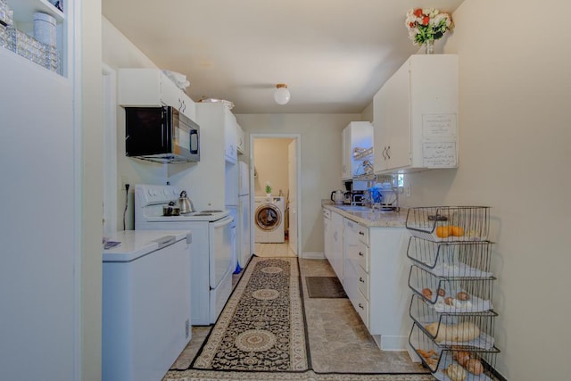 2308 Hawn Ave, Redding, CA 96002 - kitchen with black microwave, white range with electric stovetop, washer / dryer, light countertops, and white cabinetry