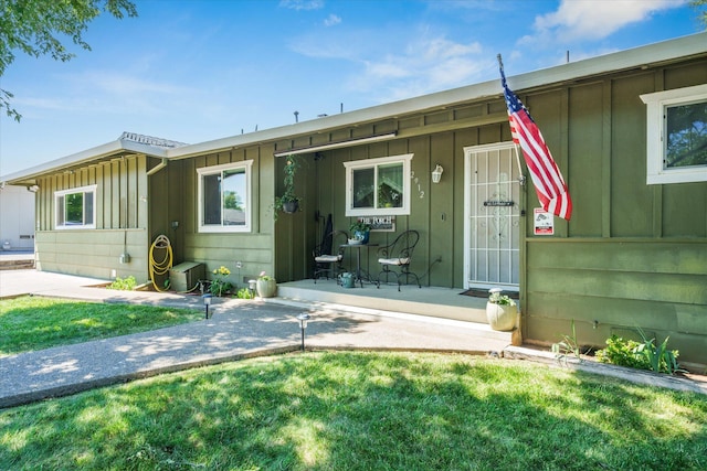 2912 Squire Ave, Redding, CA 96002 - view of front of house with board and batten siding, covered porch, and a front lawn