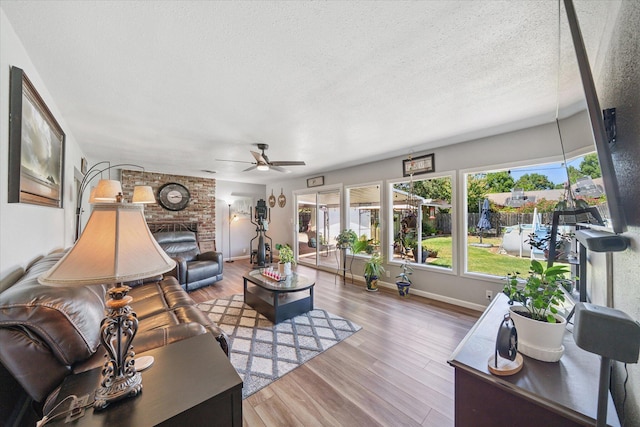 2912 Squire Ave, Redding, CA 96002 - living room featuring a ceiling fan, a brick fireplace, wood finished floors, and a textured ceiling