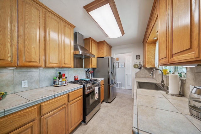 2912 Squire Ave, Redding, CA 96002 - kitchen featuring appliances with stainless steel finishes, wall chimney exhaust hood, tile countertops, decorative backsplash, and brown cabinetry