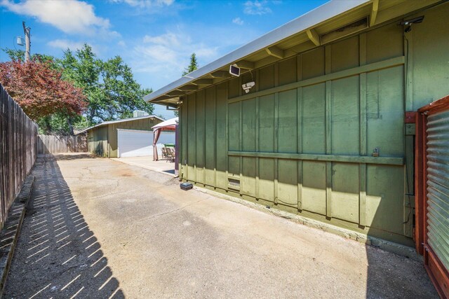 2912 Squire Ave, Redding, CA 96002 - view of home's exterior featuring board and batten siding, a detached garage, an outdoor structure, and a fenced backyard