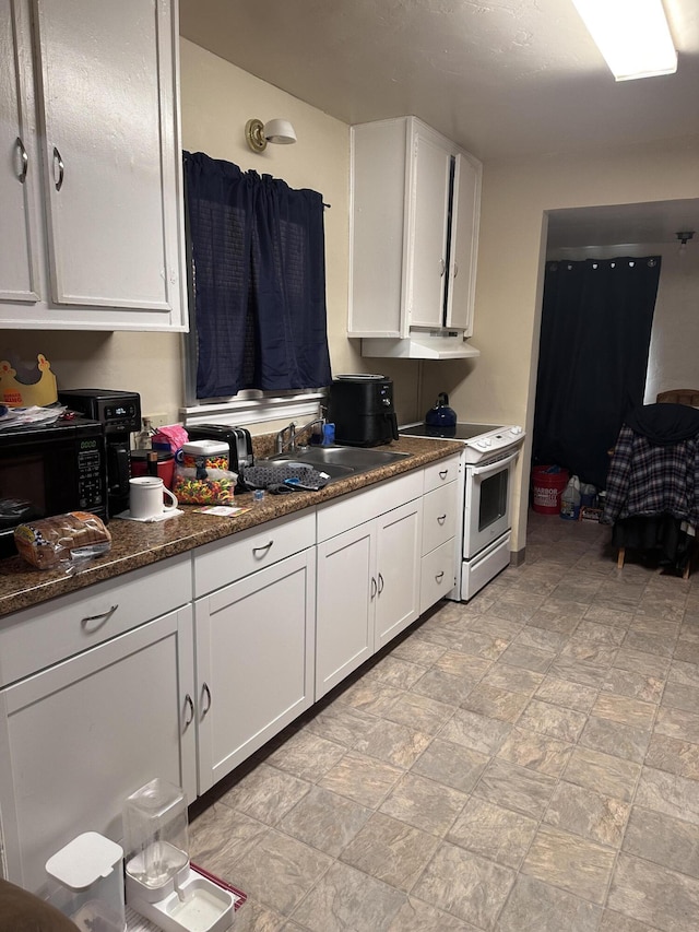 1310 Olive St, Redding, CA 96001 - kitchen with white range with electric cooktop, white cabinetry, and stone finish floors