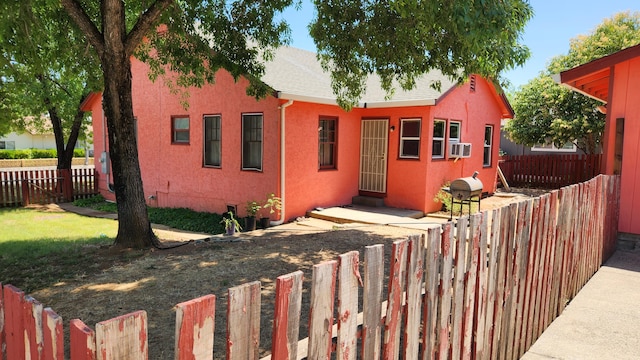 1310 Olive St, Redding, CA 96001 - view of front of house with a fenced backyard, stucco siding, cooling unit, and roof with shingles