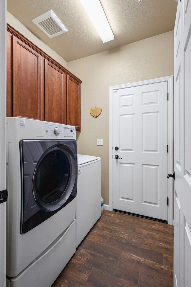 3526 Humbug Dr, Anderson, CA 96007 - laundry room with washing machine and clothes dryer, dark wood-style flooring, and cabinet space