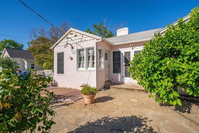 1120 Franklin St, Red Bluff, CA 96080 - view of front of house with stucco siding, a patio area, and a chimney