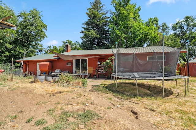 19078 Gravel Plant Rd, Redding, CA 96002 - rear view of house with a trampoline, a metal roof, a chimney, and a patio area