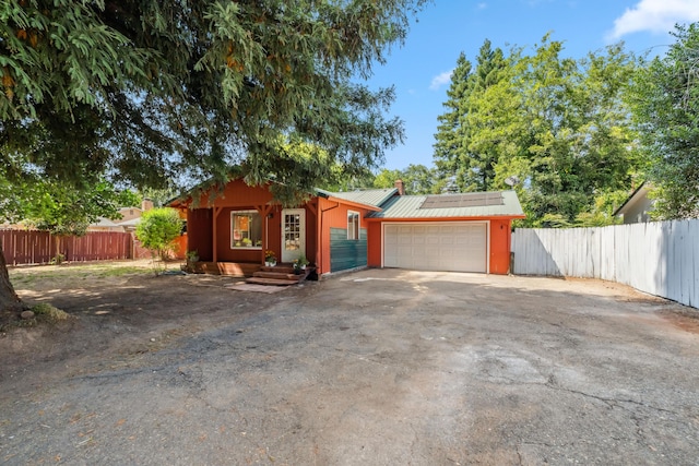 19078 Gravel Plant Rd, Redding, CA 96002 - view of front of home featuring a metal roof, solar panels, an attached garage, and asphalt driveway