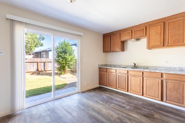 3252 Daisy St, Anderson, CA 96007 - kitchen featuring dark wood-style flooring, brown cabinets, and light stone countertops
