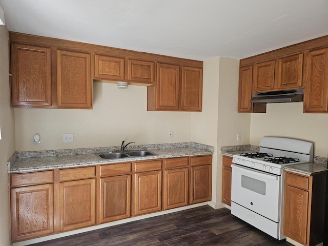 3252 Daisy St, Anderson, CA 96007 - kitchen featuring white gas range, under cabinet range hood, brown cabinetry, and dark wood-style flooring