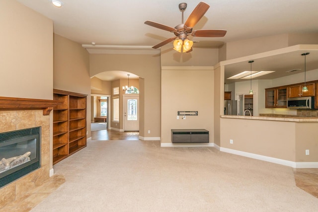 2926 Chaucer Way, Shasta Lake, CA 96019 - unfurnished living room with arched walkways, a fireplace, ceiling fan, light carpet, and high vaulted ceiling