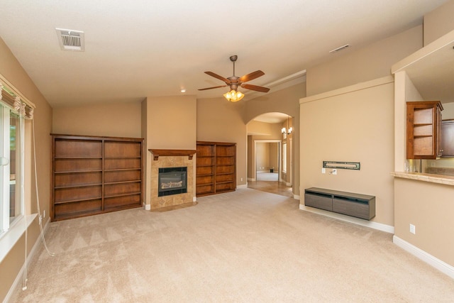 2926 Chaucer Way, Shasta Lake, CA 96019 - unfurnished living room featuring carpet floors, a ceiling fan, a fireplace, arched walkways, and vaulted ceiling