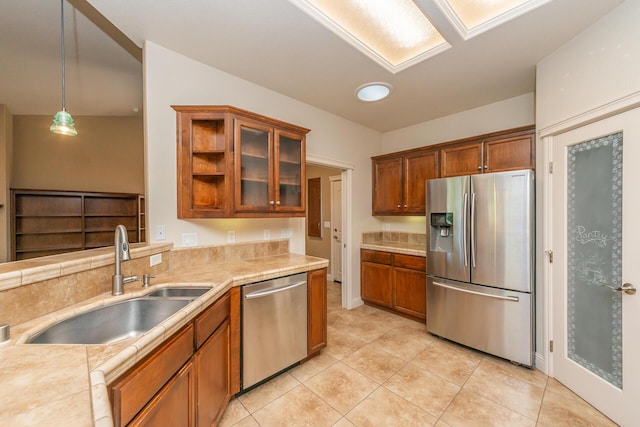 2926 Chaucer Way, Shasta Lake, CA 96019 - kitchen featuring stainless steel appliances, brown cabinetry, light tile patterned floors, glass insert cabinets, and tile counters