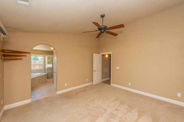 2926 Chaucer Way, Shasta Lake, CA 96019 - unfurnished bedroom featuring arched walkways, light carpet, ensuite bathroom, vaulted ceiling, and light tile patterned flooring