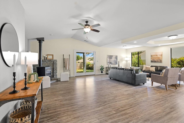 2820 Howard Dr, Redding, CA 96001 - living room featuring a ceiling fan, wood finished floors, a wood stove, plenty of natural light, and lofted ceiling