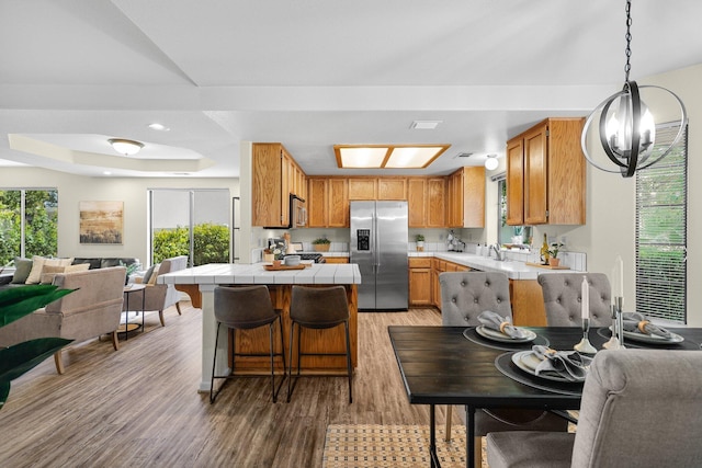 2820 Howard Dr, Redding, CA 96001 - kitchen featuring stainless steel appliances, open floor plan, tile counters, a raised ceiling, and a kitchen breakfast bar