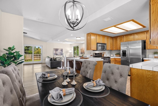 2820 Howard Dr, Redding, CA 96001 - dining space featuring a chandelier, wood finished floors, vaulted ceiling, and recessed lighting