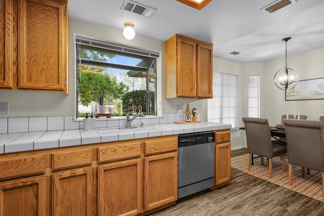 2820 Howard Dr, Redding, CA 96001 - kitchen with dishwasher, wood finished floors, a chandelier, pendant lighting, and brown cabinetry