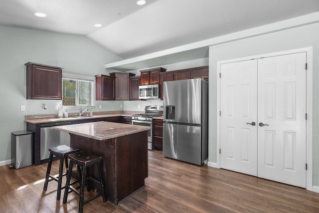 3525 Humbug Dr, Anderson, CA 96007 - kitchen featuring appliances with stainless steel finishes, lofted ceiling, a kitchen island, dark wood-type flooring, and dark brown cabinets