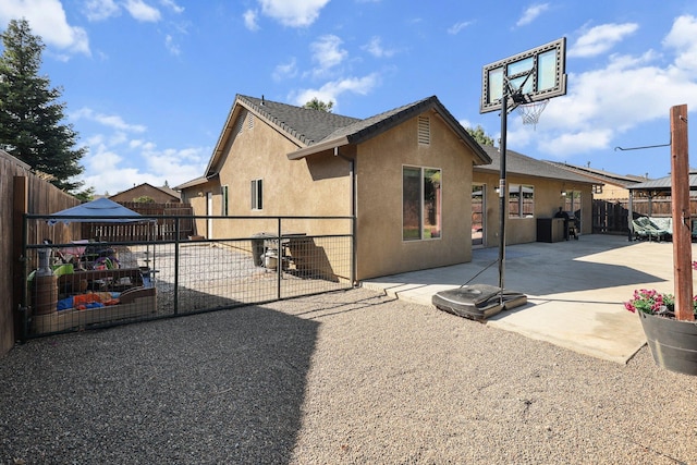 3525 Humbug Dr, Anderson, CA 96007 - back of property featuring stucco siding, a fenced backyard, a patio, and a gate