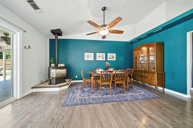 3385 Pioneer Ln, Redding, CA 96001 - dining room featuring a wood stove, wood finished floors, a ceiling fan, and vaulted ceiling