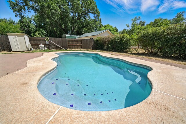 3385 Pioneer Ln, Redding, CA 96001 - view of swimming pool with a storage unit, a fenced backyard, a patio, and view of scattered trees