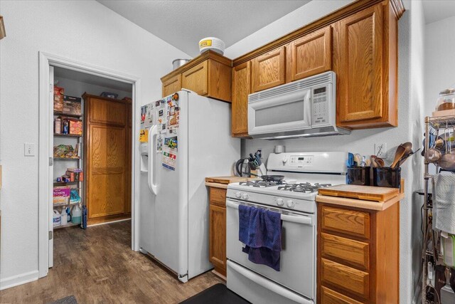 726 Stonebriar Trl, Redding, CA 96003 - kitchen featuring white appliances, dark wood finished floors, brown cabinets, and light countertops