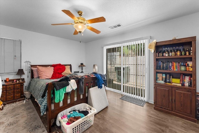 726 Stonebriar Trl, Redding, CA 96003 - bedroom with wood finished floors, ceiling fan, and a textured ceiling