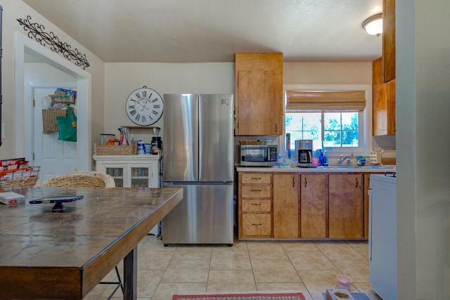 37153/55 Siskiyou St, Burney, CA 96028 - kitchen with appliances with stainless steel finishes, light tile patterned flooring, brown cabinetry, and light countertops
