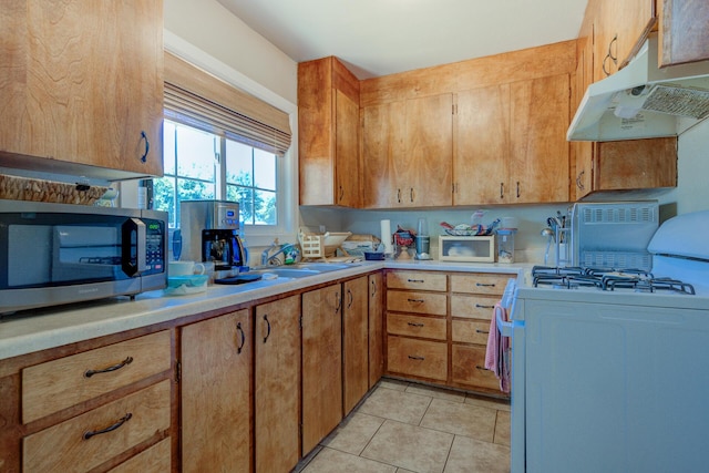 37153/55 Siskiyou St, Burney, CA 96028 - kitchen with white gas range oven, stainless steel microwave, under cabinet range hood, light countertops, and light tile patterned floors