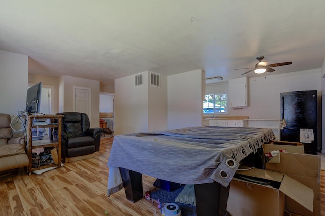 37153/55 Siskiyou St, Burney, CA 96028 - bedroom with light wood-style flooring, freestanding refrigerator, and a ceiling fan