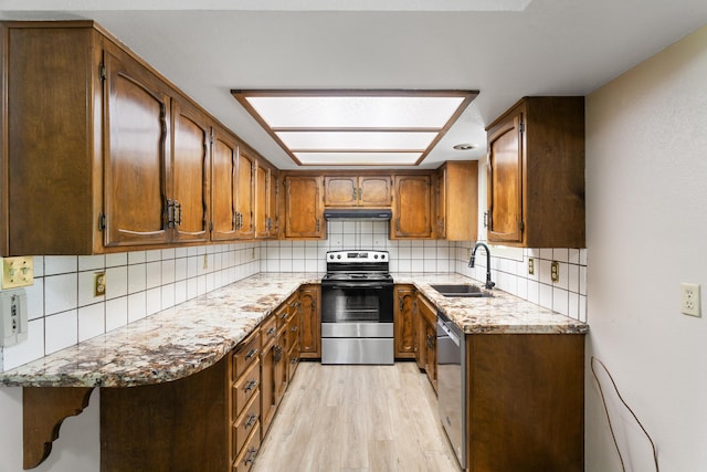 5858 Deschutes Rd, Anderson, CA 96007 - kitchen featuring stainless steel appliances, under cabinet range hood, light wood finished floors, and tasteful backsplash