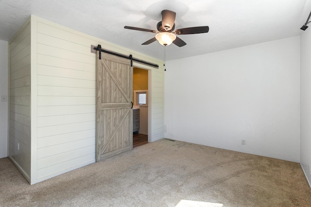 5858 Deschutes Rd, Anderson, CA 96007 - unfurnished bedroom featuring a barn door, carpet flooring, and ceiling fan